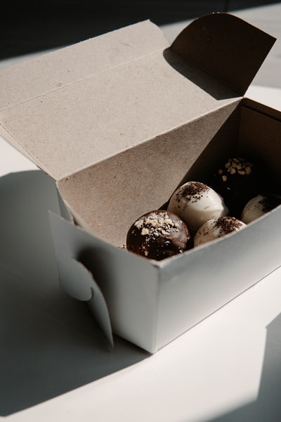 White and brown chocolate wrapped biscuit in brown carton
